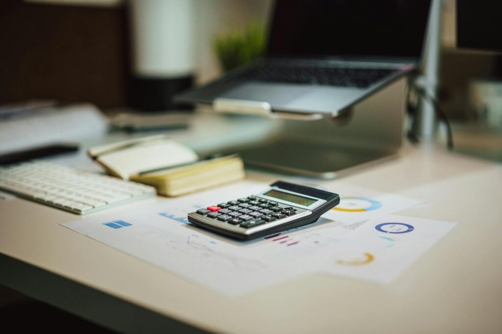 A calculator and documents placed on a table 