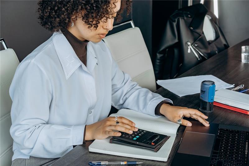 mental health professional reviewing finances with a calculator and laptop