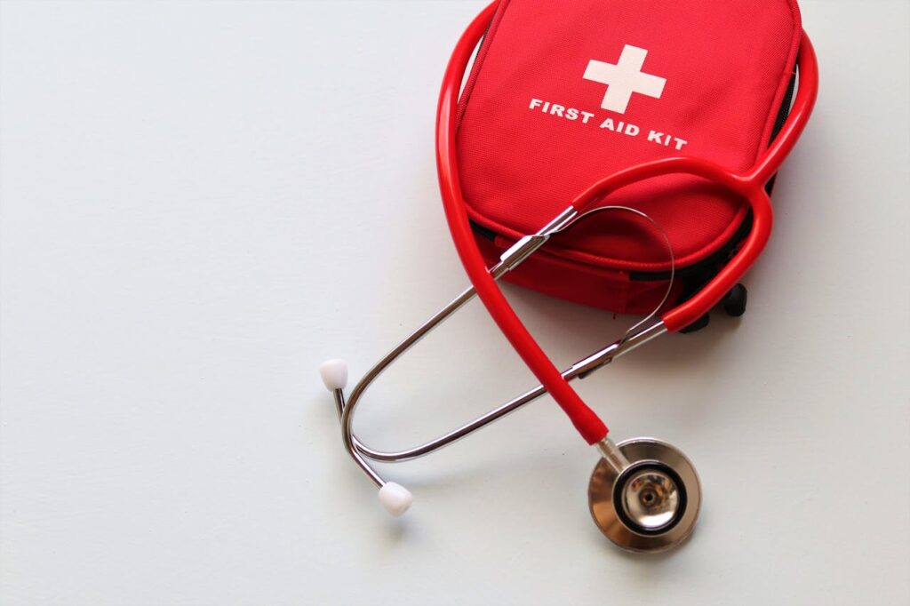 red first aid kit paired with a stethoscope
