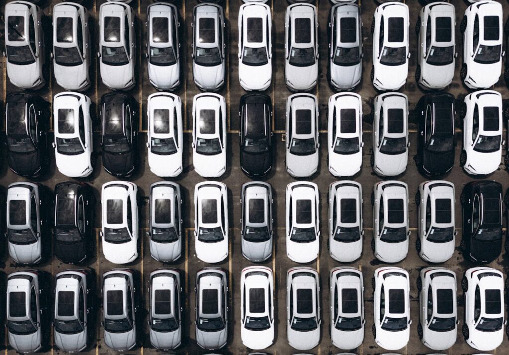 Top view of cars parked in a parking lot of a car dealership